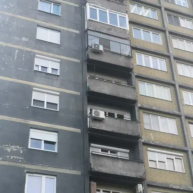 Niz zastakljenih balkona na visokoj stambenoj zgradi — PVC stolarija